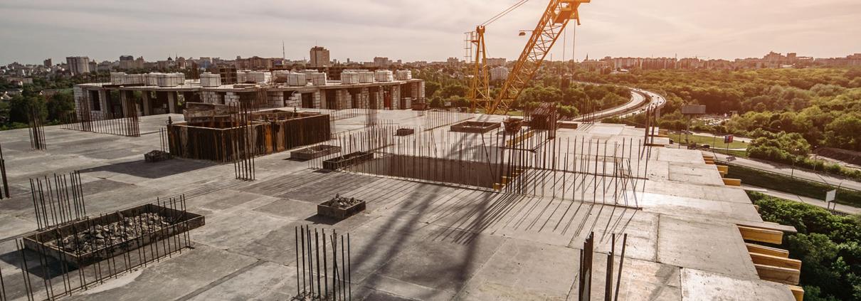 Roof of construction site of new multi-storey residential building, industrial construction crane and other industry equipment