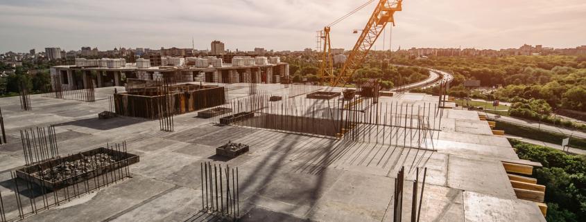 Roof of construction site of new multi-storey residential building, industrial construction crane and other industry equipment