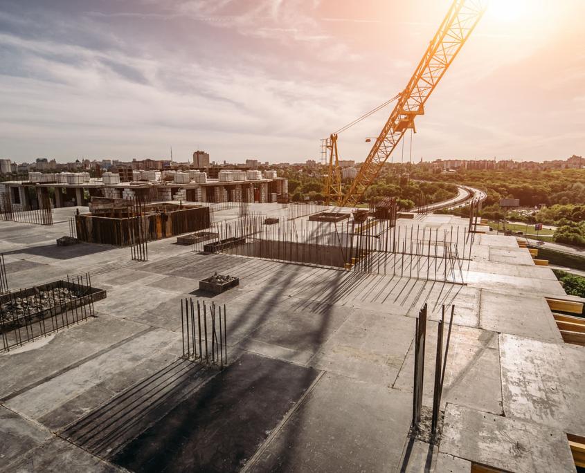Roof of construction site of new multi-storey residential building, industrial construction crane and other industry equipment